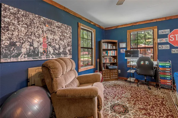a living room with furniture a large window and bookshelf