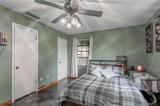 a bedroom with a large bed and a chandelier