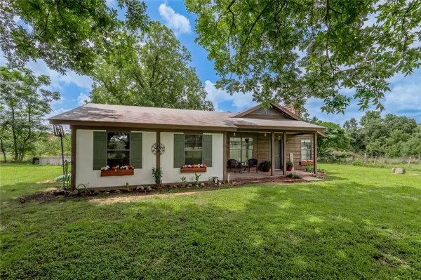 a front view of a house with a garden and porch