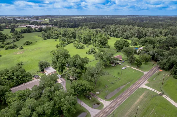 an aerial view of residential houses with outdoor space and trees