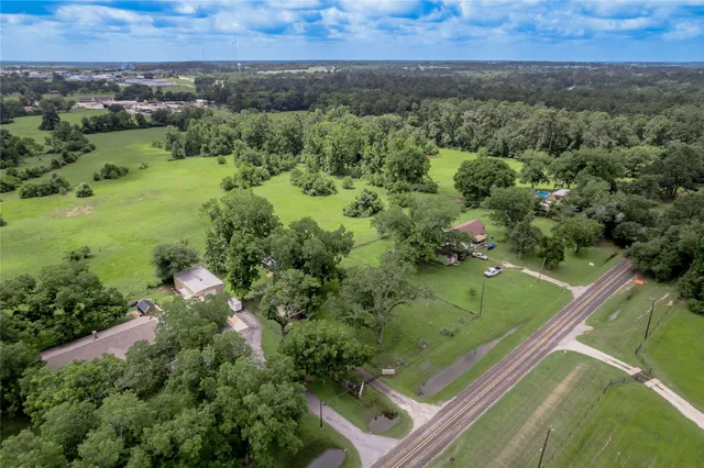 an aerial view of residential houses with outdoor space and trees