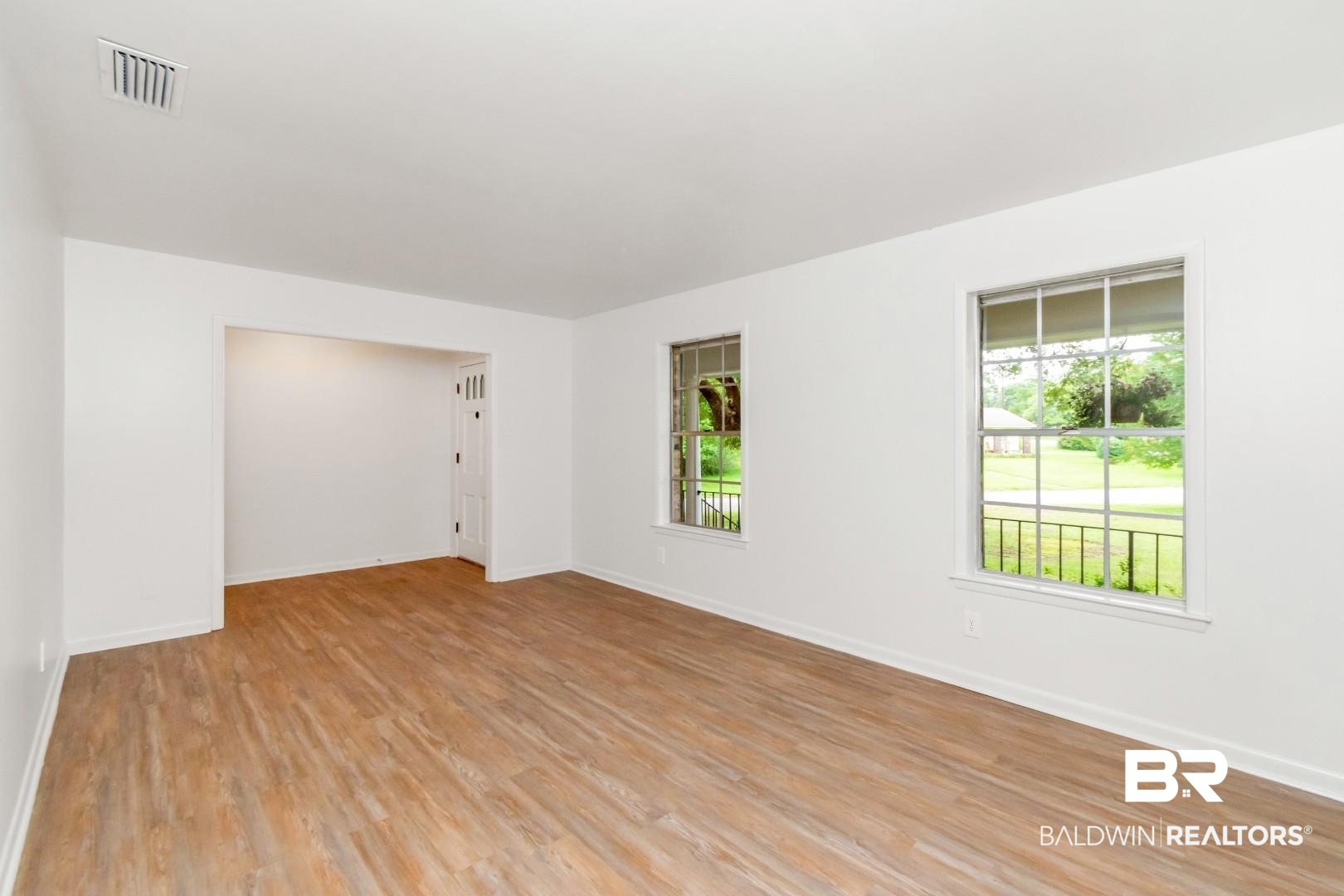 5217 Perin Road Mobile, AL 36693 - Photo 5 of 45 Spacious interior room featuring wood-finish flooring, white walls, and bright trim