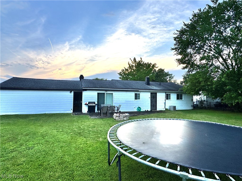 5945 Randy Road Bedford Heights, OH 44146 - Photo 3 of 13 Back of house featuring a trampoline and a yard