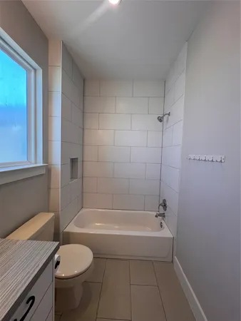 a white bath tub sitting next to a toilet