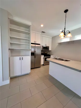 a kitchen with white cabinets and stainless steel appliances