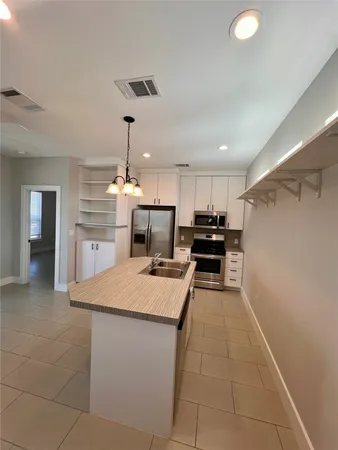 a kitchen with kitchen island a counter top space appliances and cabinets