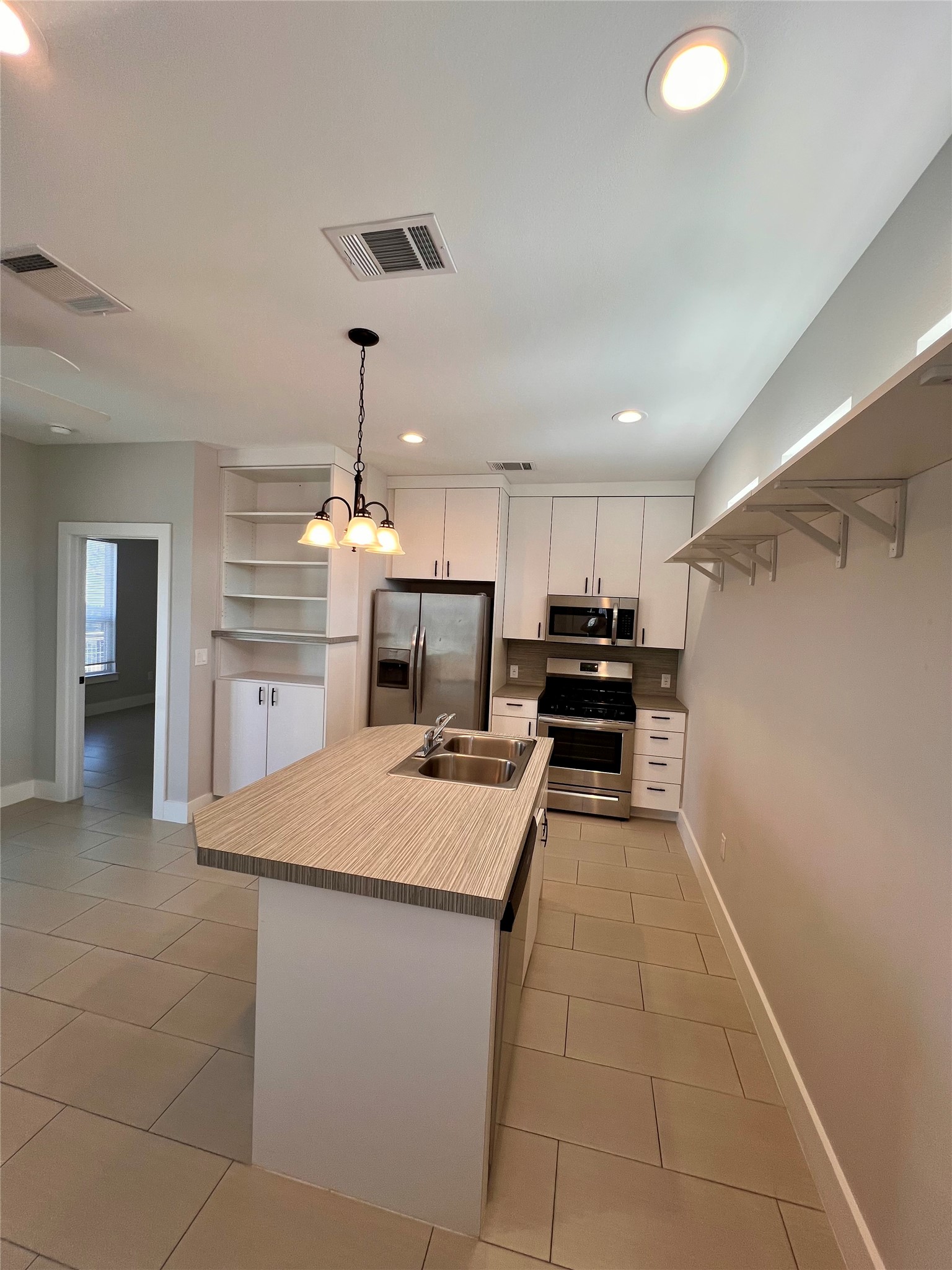 1101 Stobaugh Street, Unit B Austin, TX 78757 - Photo 5 of 21 a kitchen with kitchen island a counter top space appliances and cabinets