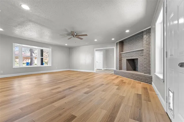 a view of empty room with wooden floor and fireplace