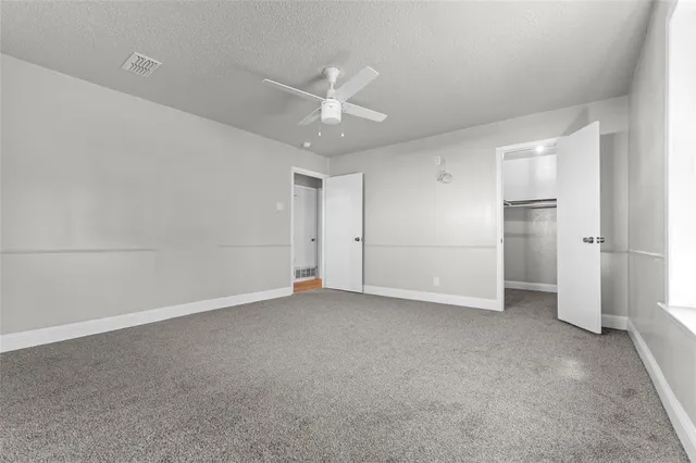 an empty room with closet and windows