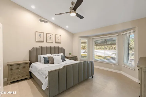 a bedroom with a large bed and a chandelier