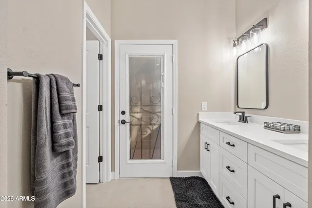 a bathroom with a double vanity sink mirror and shower