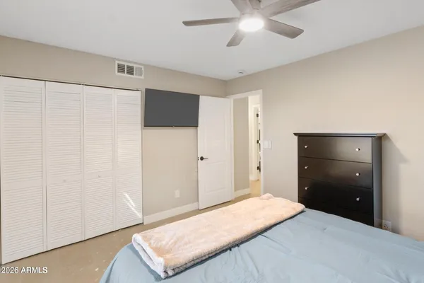 a bedroom with a bed and a ceiling fan