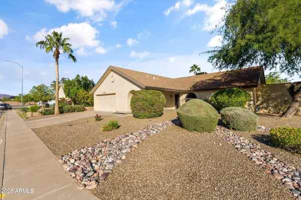 a view of a house with a yard and potted plants