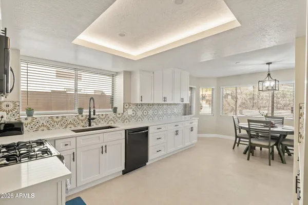 a kitchen with granite countertop a sink stove and cabinets