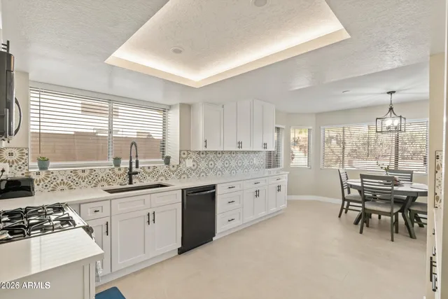 a kitchen with granite countertop a sink stove and cabinets