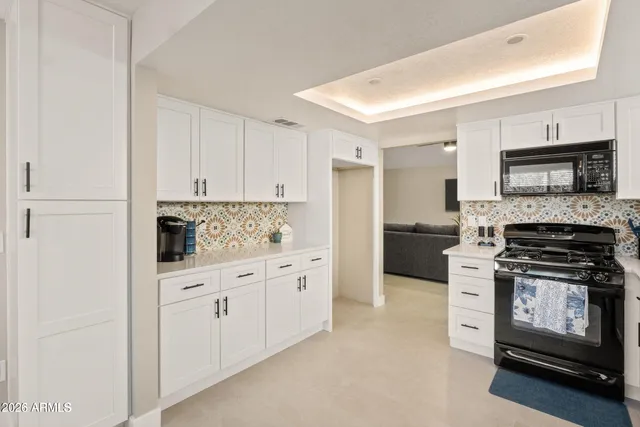 a kitchen with granite countertop white cabinets and stainless steel appliances