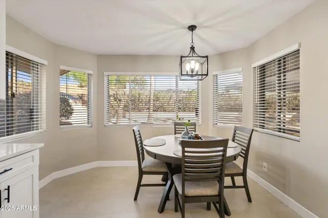 a dining room with furniture large windows and wooden floor