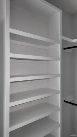 a view of a walk in closet with wooden floor