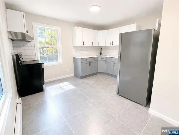 a kitchen with a refrigerator a stove top oven a sink and dishwasher with wooden floor