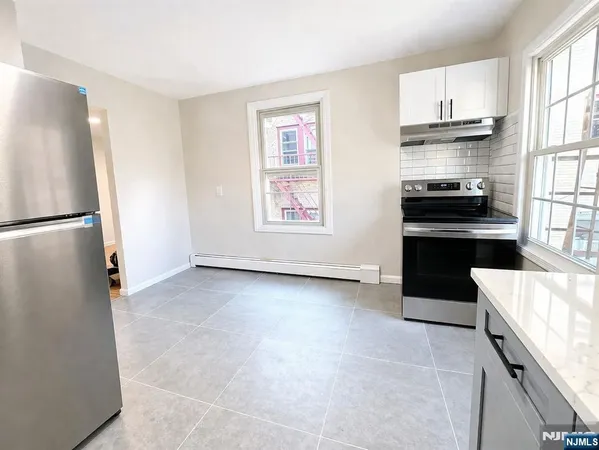 a kitchen with granite countertop a refrigerator and a stove