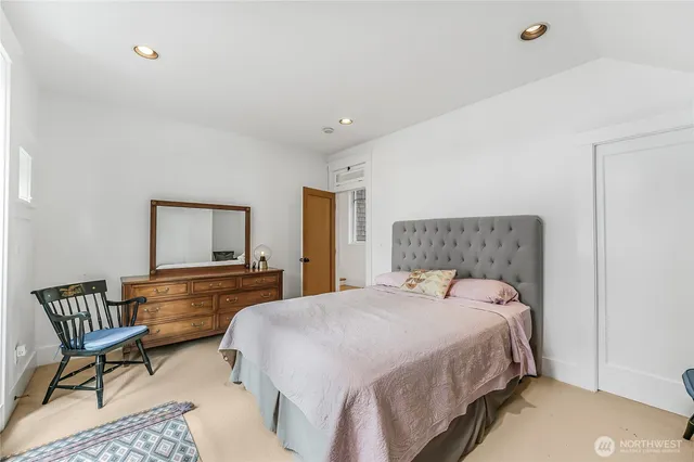 a bedroom with a bed and a lounge chair