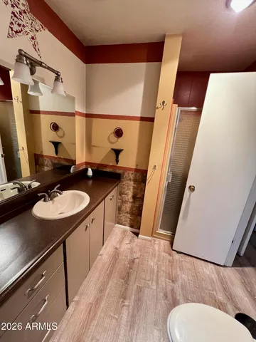 a bathroom with a sink and mirror with toilet