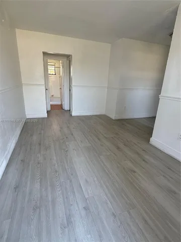 an empty room with wooden floor and white walls