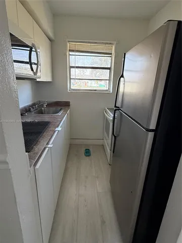 a kitchen with white cabinets and white appliances