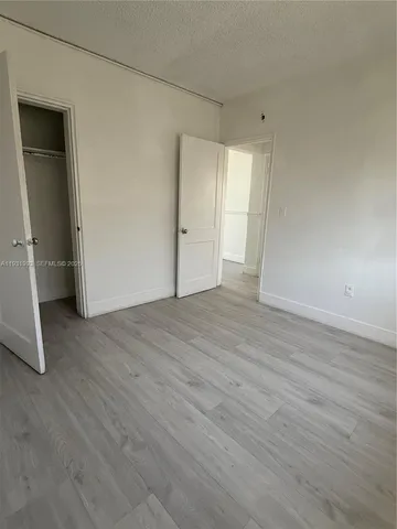 an empty room with wooden floor and closet
