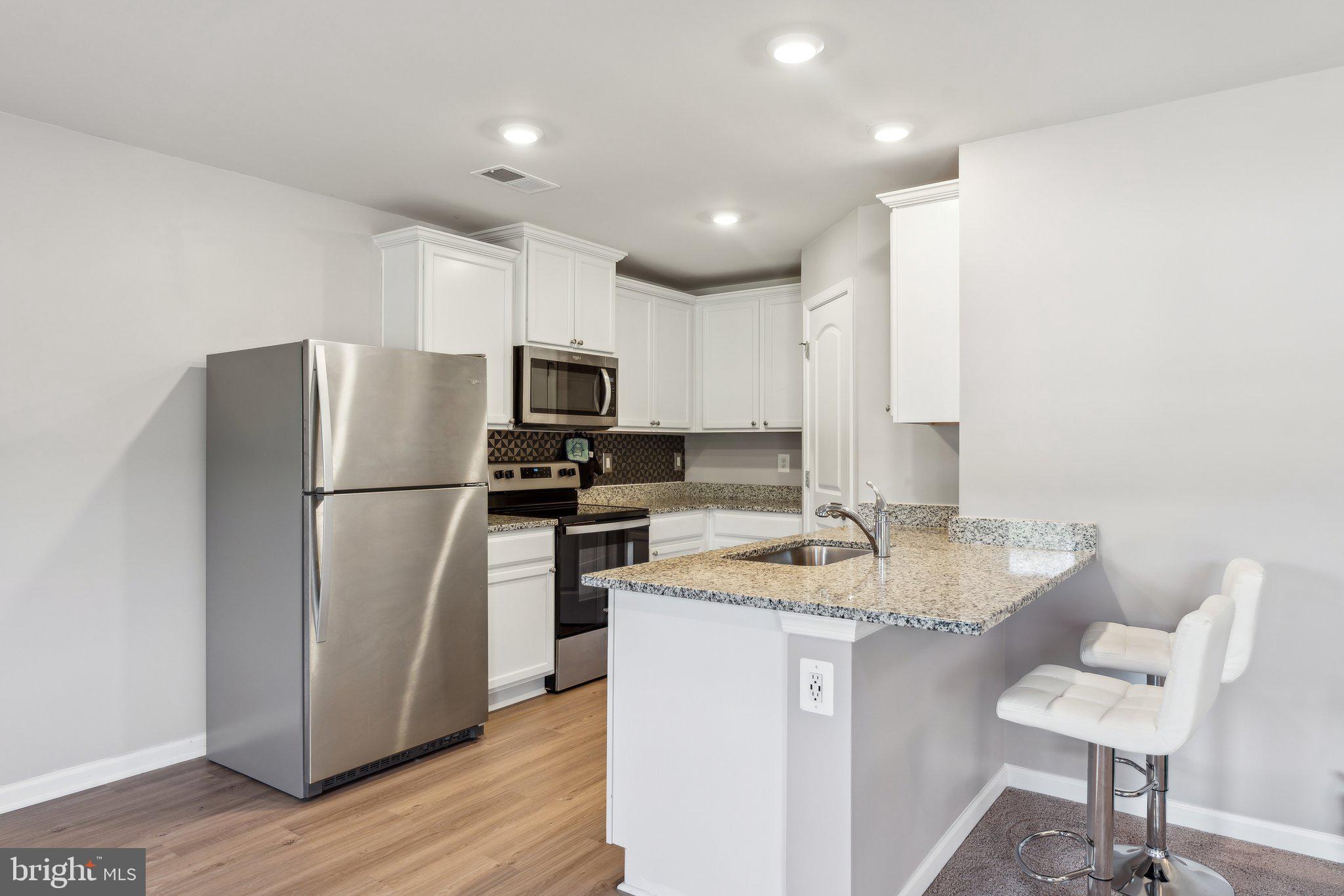 17026 Rollins Road Bowling Green, VA 22427 - Photo 8 of 19 a kitchen with a refrigerator a stove cabinets and wooden floor