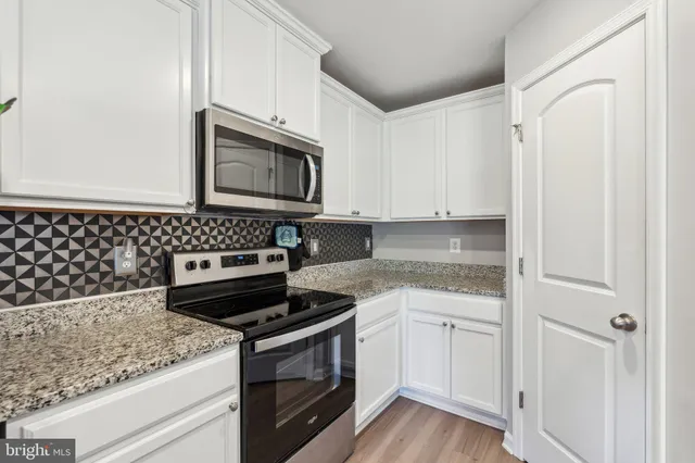 a kitchen with granite countertop cabinets and steel stainless steel appliances