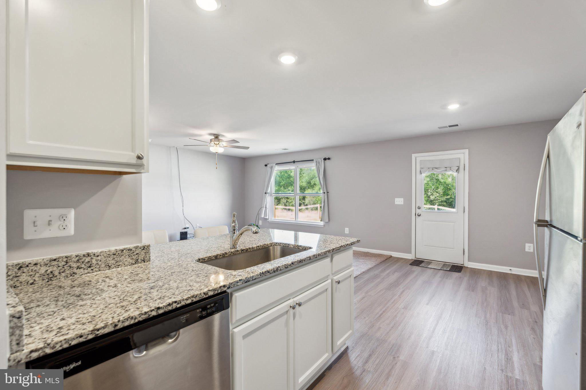 17026 Rollins Road Bowling Green, VA 22427 - Photo 10 of 19 a kitchen with granite countertop a sink and a window