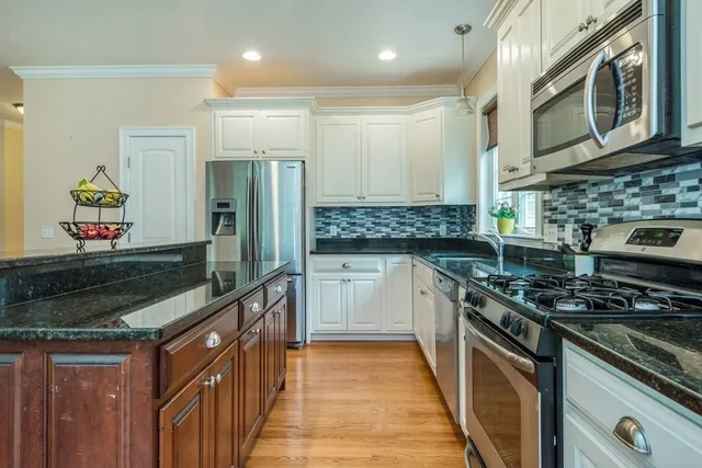 a kitchen with stainless steel appliances granite countertop a stove and a sink