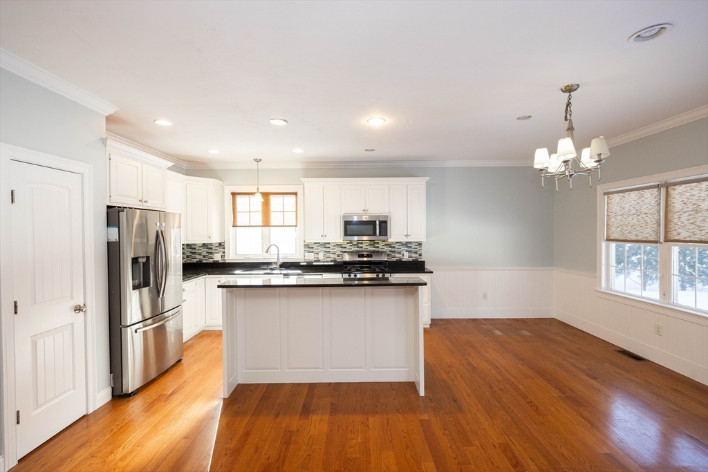 4 Cyrus Way, Unit 4 Northborough, MA 01532 - Photo 4 of 17 a kitchen with stainless steel appliances granite countertop a refrigerator a sink dishwasher a stove and white countertops with wooden floor