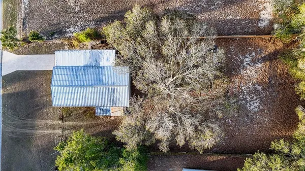 a view of a house with a yard covered in the roadside