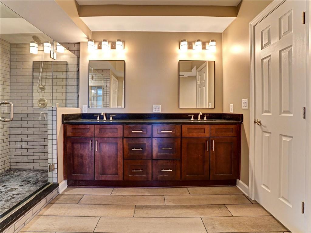 3435 Kingsboro Road Northeast, Unit 1601 Atlanta, GA 30326 - Photo 19 of 54 a bathroom with a sink a mirror and a shower