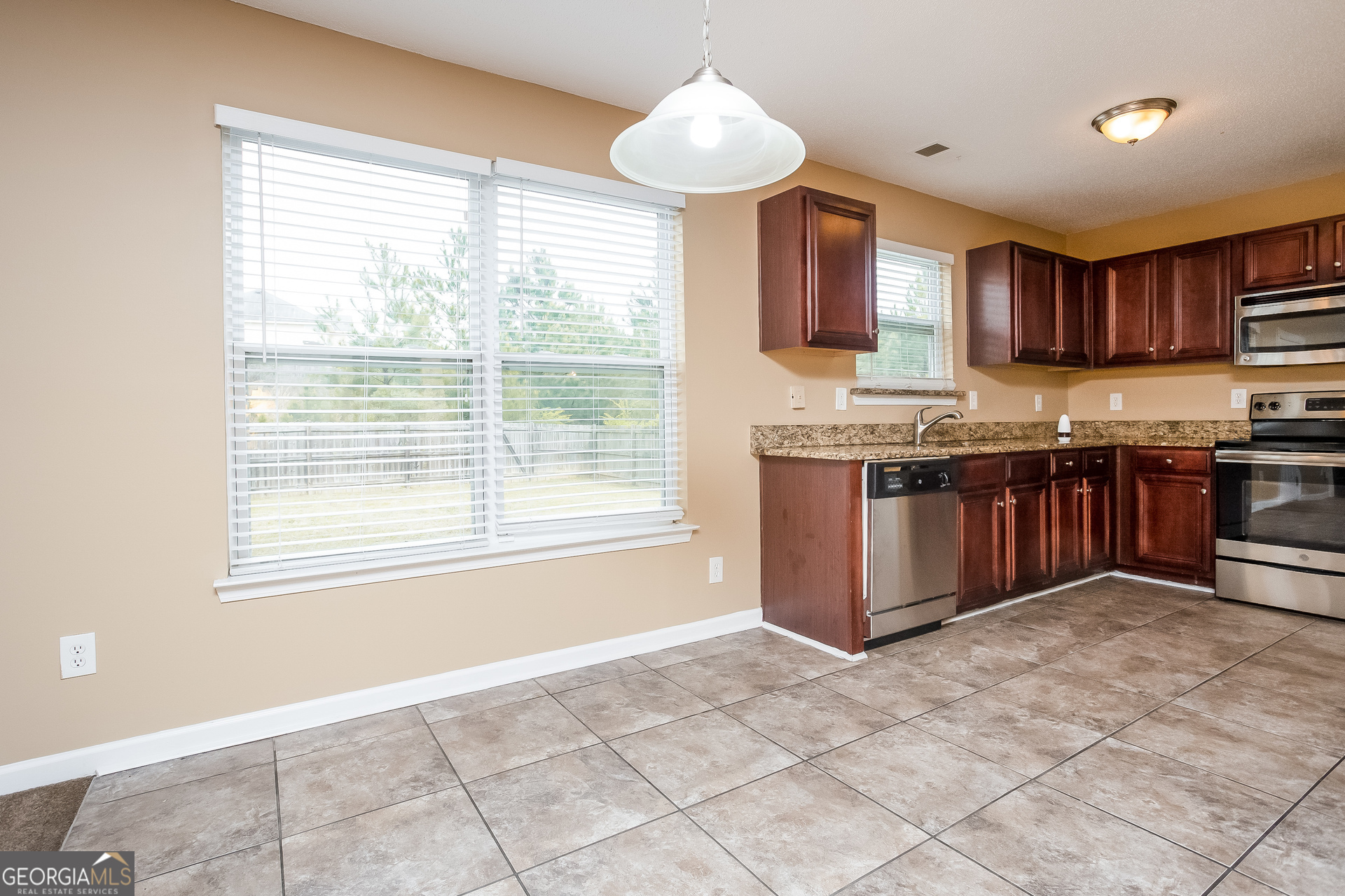 8311 Champion Trail Fairburn, GA 30213 - Photo 5 of 17 a kitchen with stainless steel appliances granite countertop a stove sink and cabinets