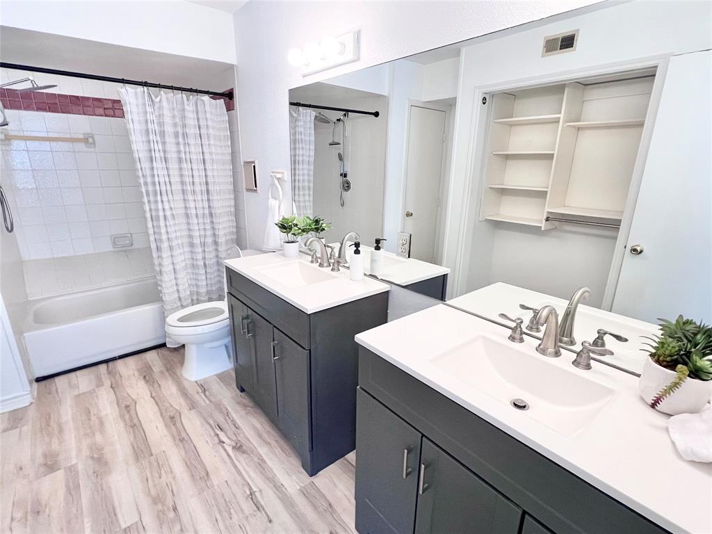 2450 Wickersham Lane, Unit 106 Austin, TX 78741 - Photo 4 of 13 a bathroom with a double vanity sink toilet and shower