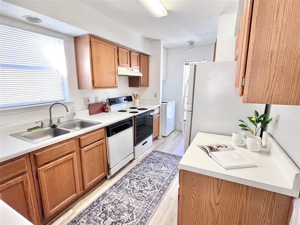 2450 Wickersham Lane, Unit 106 Austin, TX 78741 - Photo 5 of 13 a kitchen with a sink stove and refrigerator