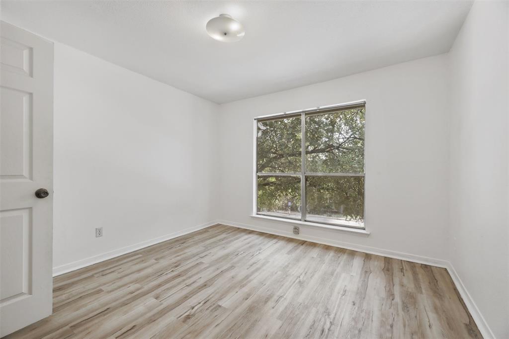 2450 Wickersham Lane, Unit 106 Austin, TX 78741 - Photo 7 of 13 an empty room with wooden floor and windows