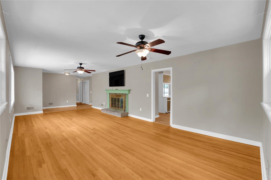 106 Mitchell Avenue Clemson, SC 29631 - Photo 7 of 31 Bright and airy living room with gleaming hardwood floors, a cozy fireplace, and ample natural light.