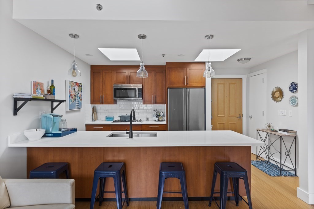 a kitchen with stainless steel appliances granite countertop a sink and a refrigerator