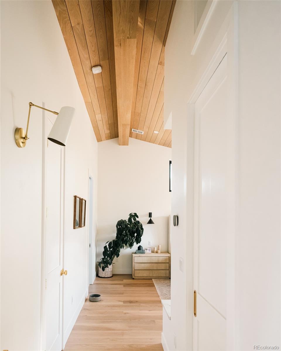 2745 Deframe Road Golden, CO 80401 - Photo 39 of 50 a hallway with white doors wooden floor and front door
