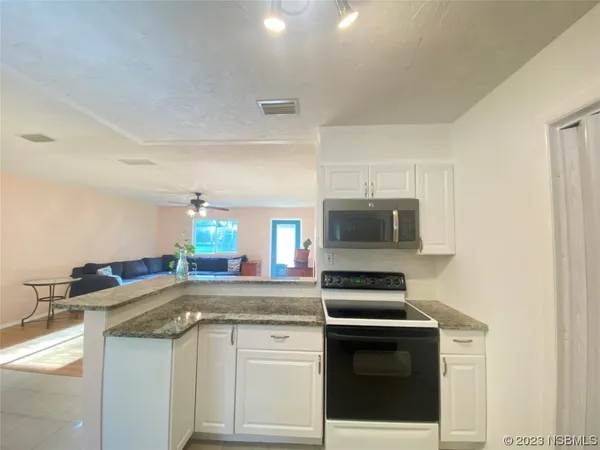 a kitchen with stainless steel appliances a stove microwave and sink