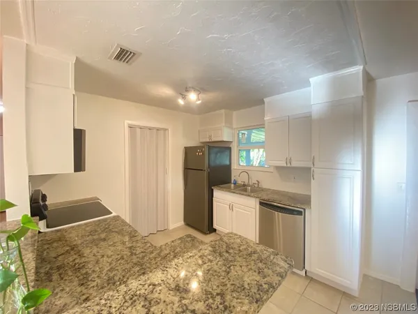 a kitchen with stainless steel appliances granite countertop a refrigerator and a sink