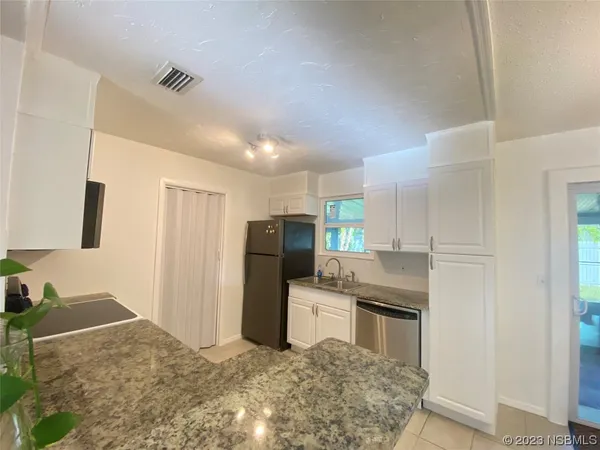 a kitchen with stainless steel appliances kitchen island granite countertop a refrigerator and a stove top oven