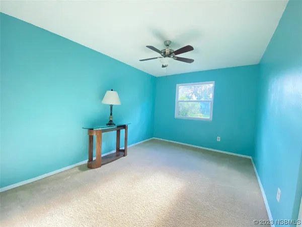 a view of a room with a ceiling fan and a window