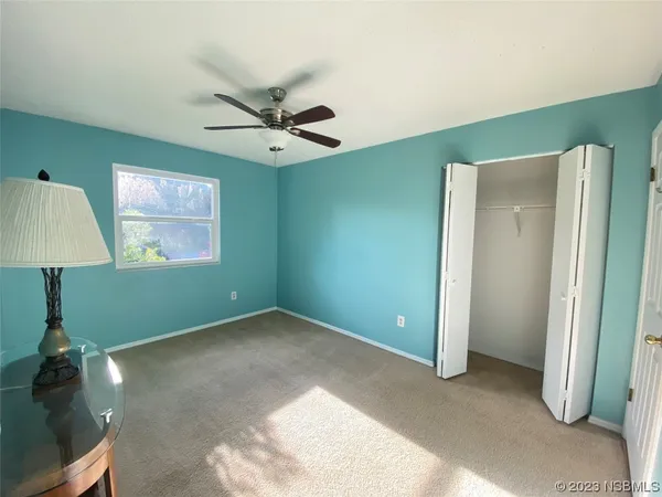 en empty room with window and ceiling fan