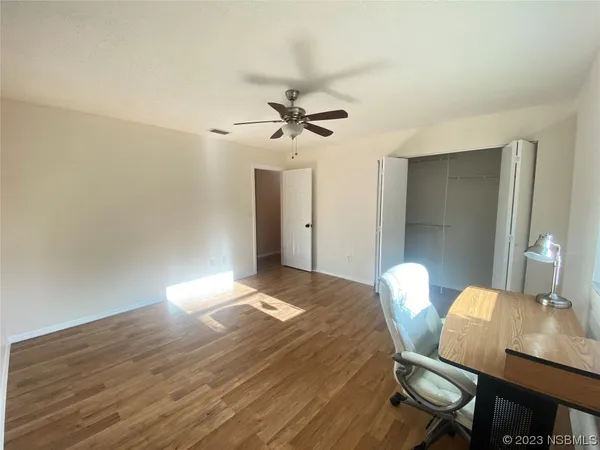 an empty room with a window and a fan