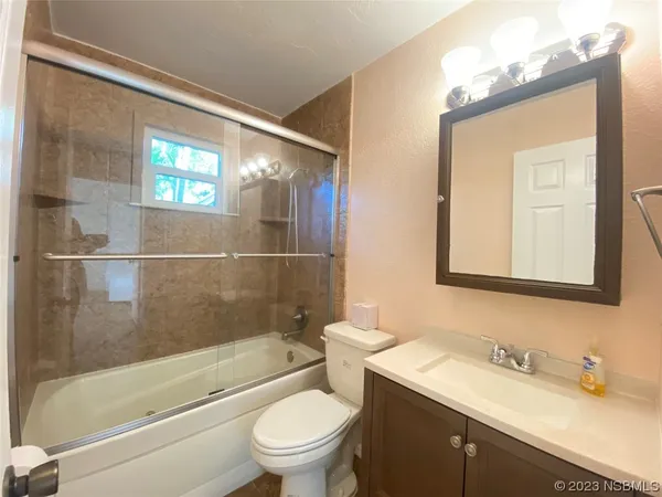 a view of a livingroom with a ceiling fan and wooden floor
